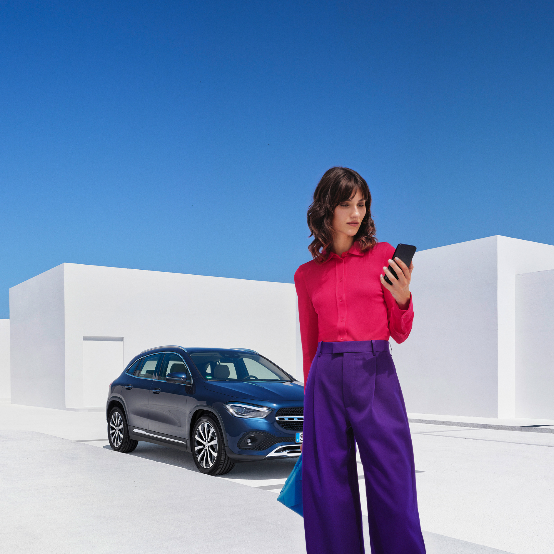 Eine Frau stellt per Mercedes me App auf ihrem Smartphone eine Verbindung mit ihrem Mercedes-Benz her. Eine Frau stellt per Mercedes me App auf ihrem Smartphone eine Verbindung mit ihrem Mercedes-Benz her.