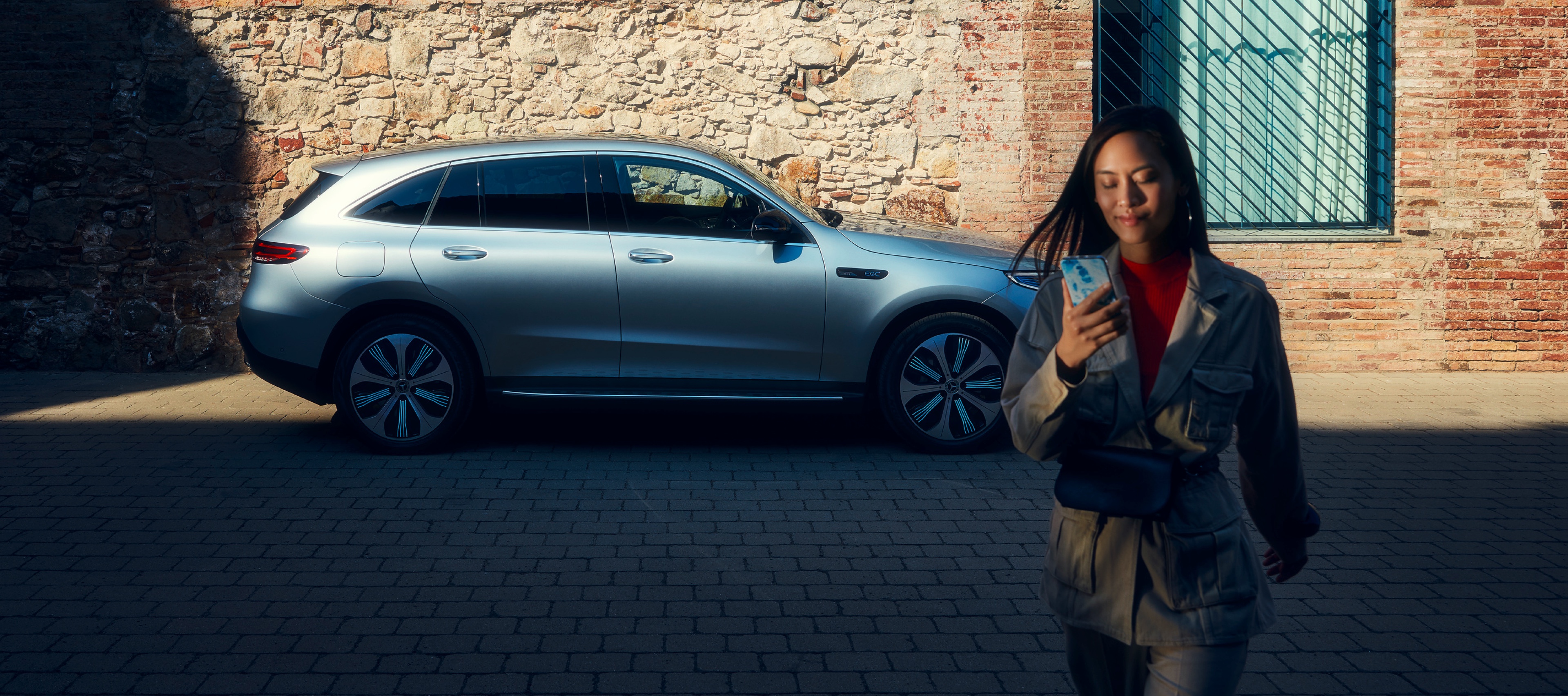 Eine Frau ist mit dem Smartphone per Digitalen Extras mit ihrem Mercedes-Benz verbunden. Eine Frau ist mit dem Smartphone per Digitalen Extras mit ihrem Mercedes-Benz verbunden.