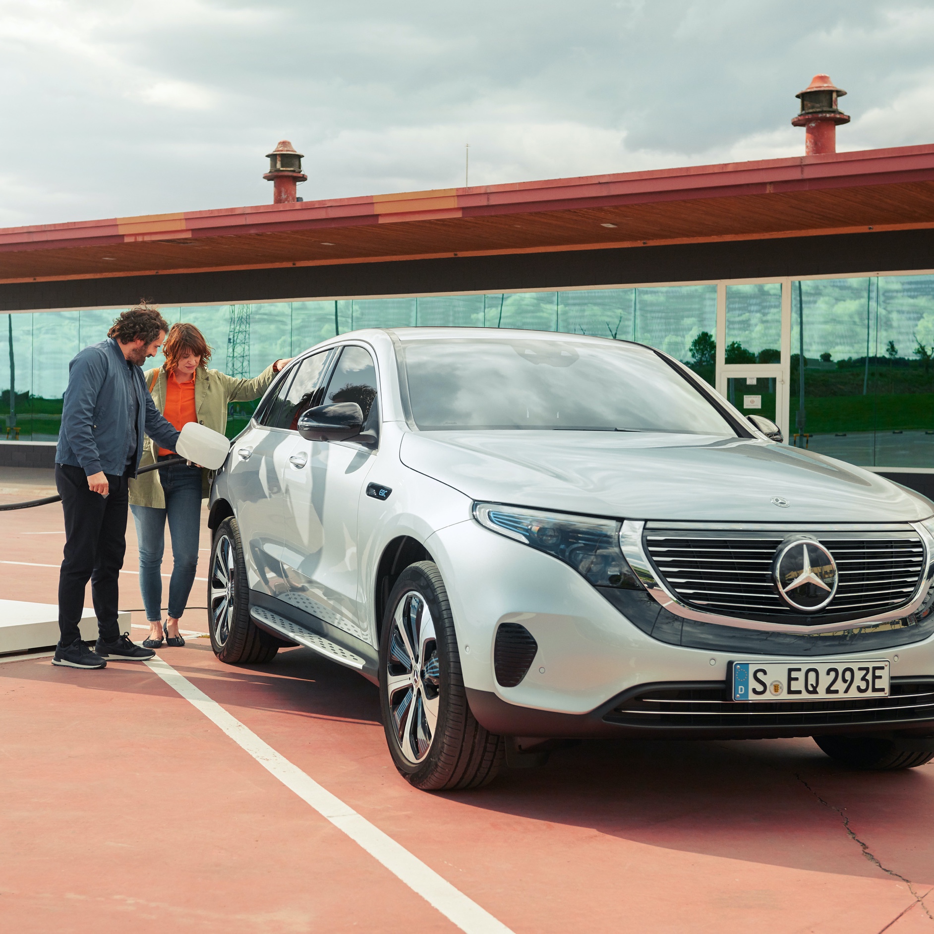 Ein Mann und eine Frau laden ihren Mercedes-Benz bequem an einer Ladesäule per Digitalen Extras zum Thema Charge. Ein Mann und eine Frau laden ihren Mercedes-Benz bequem an einer Ladesäule per Digitalen Extras zum Thema Charge.