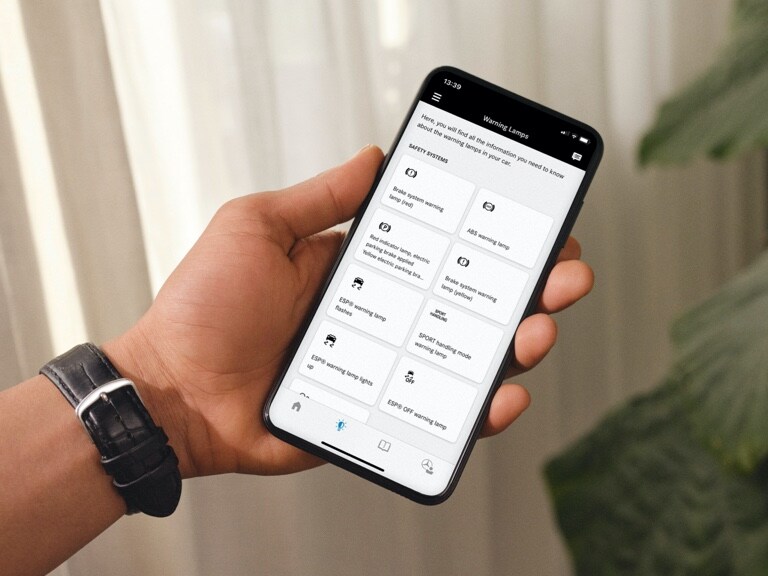 Auf einem Smartphone zeigt die Mercedes me Service App an, was welche Warnleuchte in einem Mercedes-Benz zu bedeuten hat.