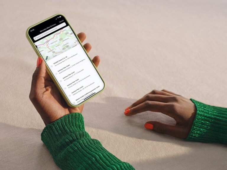 Auf einem Smartphone werden in der Nähe liegende Mercedes-Benz Servicepartner angezeigt.