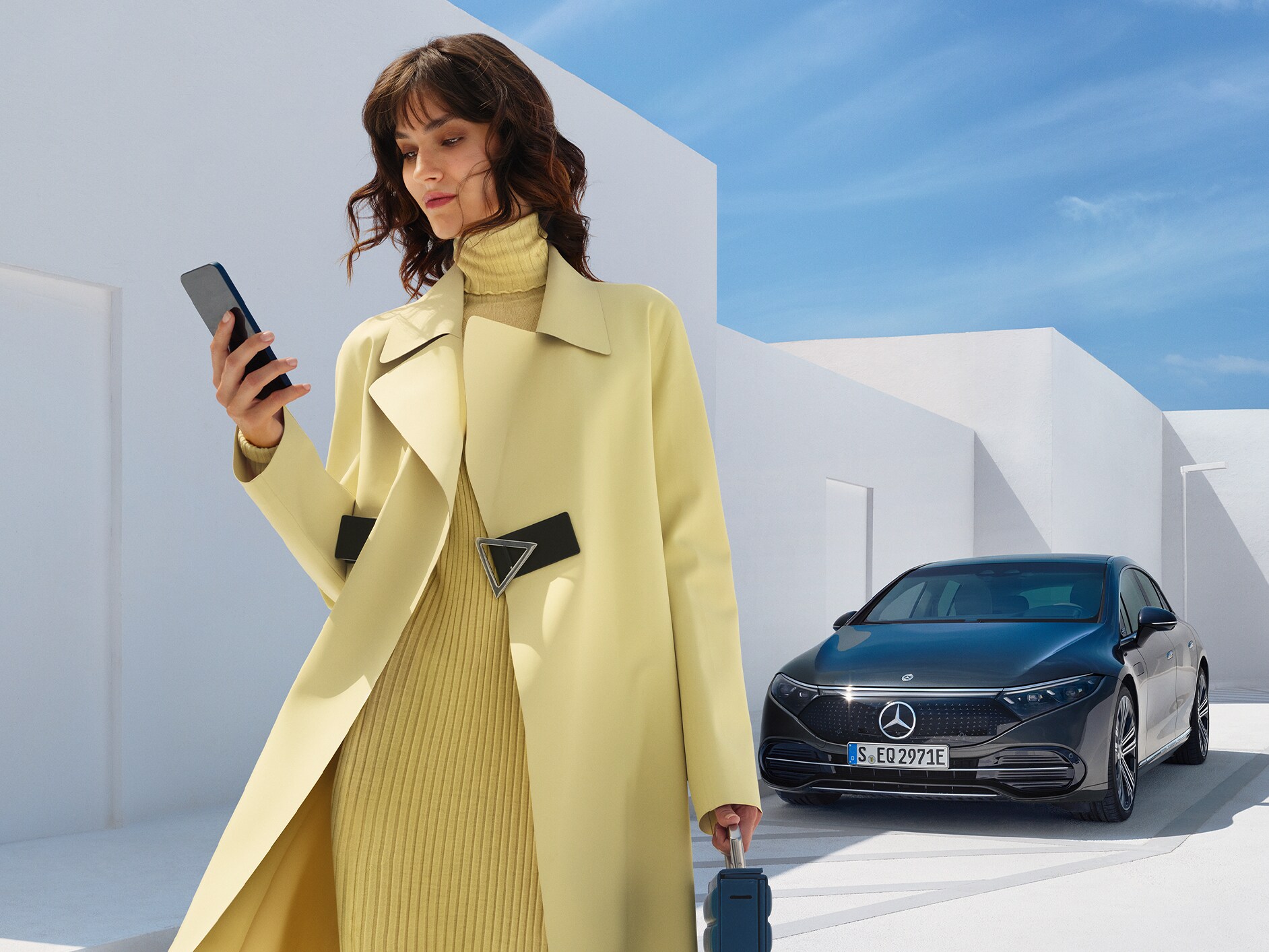 Eine Frau steht vor der EQS Limousine von Mercedes-Benz.